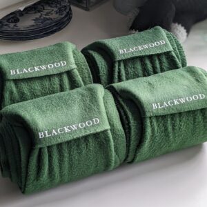 Four green polos with a last name in heat transfer.