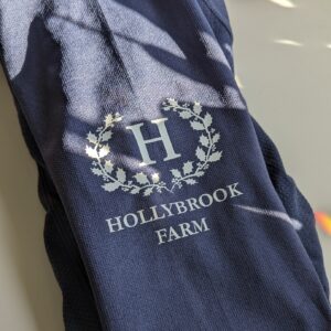 Shirt sleeve with a Hollybrook barn logo.